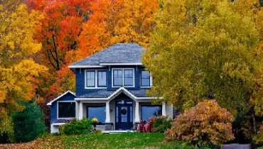 Fall landscape surrounding two-story home.