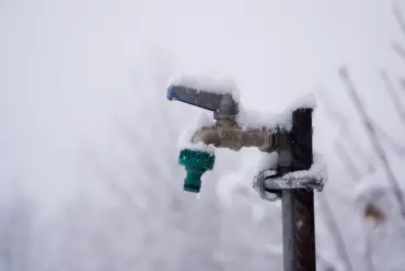 Snow covering frozen water spigot.