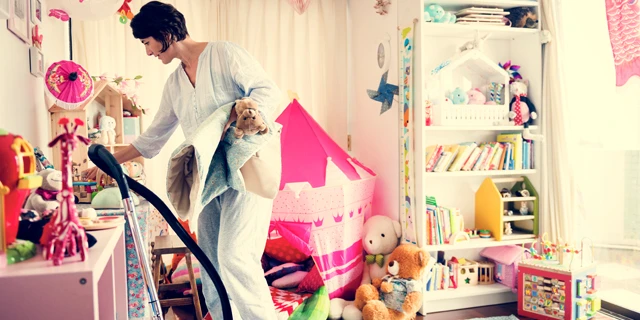 woman cleaning kids room with toys